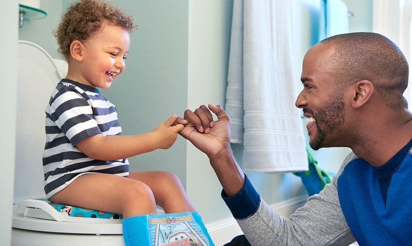 Dad pinky promises son a reward if he uses the potty in the bathroom